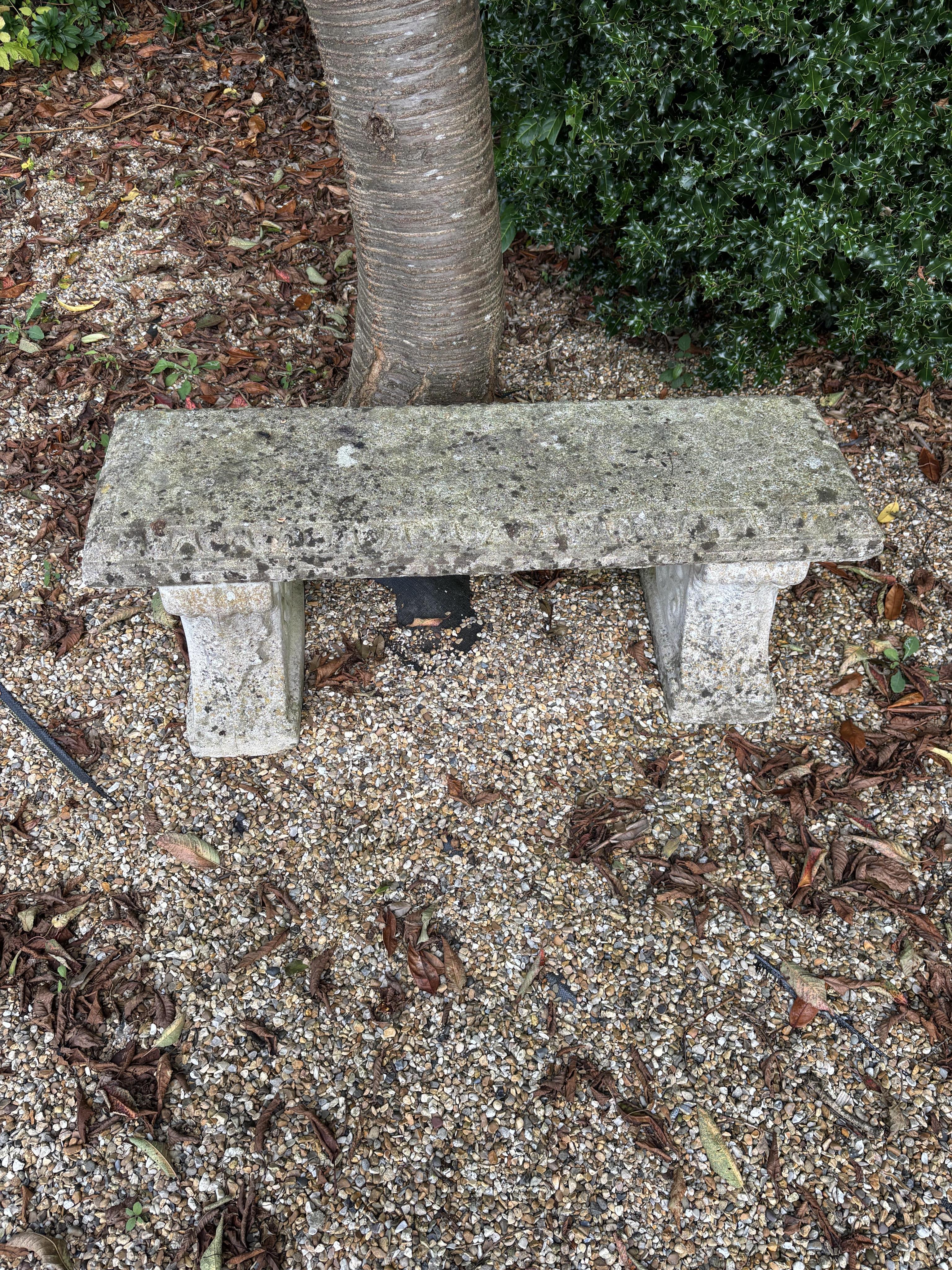 Two reconstituted stone benches, one curved, width 110cm, height 40cm, the other straight, width 114cm, height 44cm. Condition - both weathered, otherwise good condition